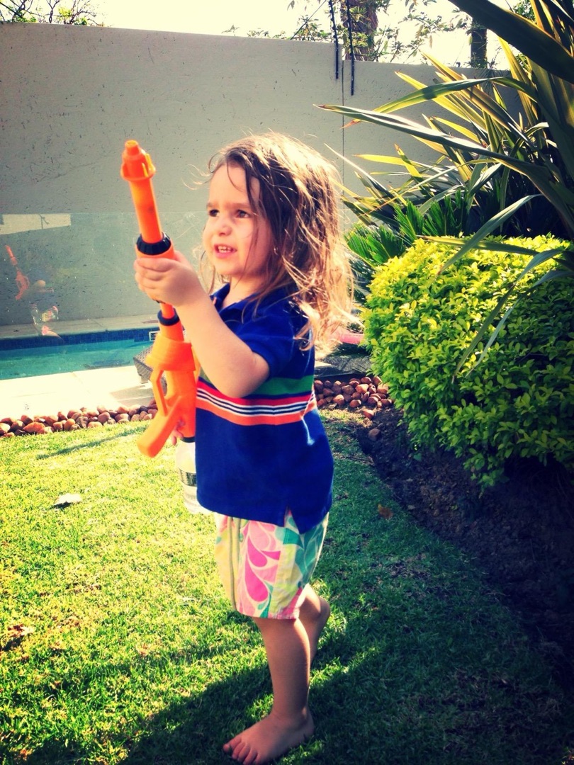 Taye with water gun in garden